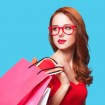 Redhead girl with shopping bags  blue background.